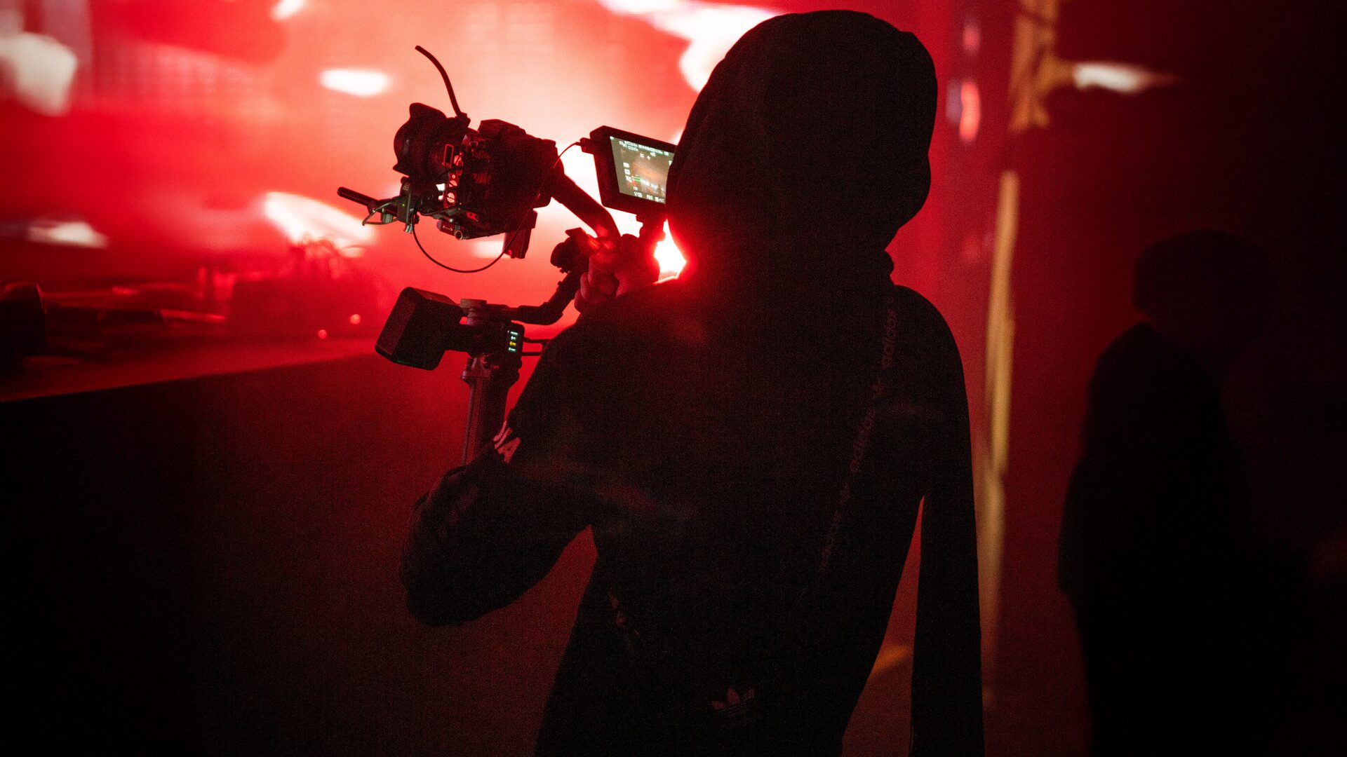 Filmmaker operating a camera rig under red light